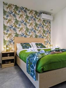a bedroom with a bed with a green comforter at I colori della Sicilia in Cinisi
