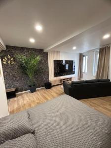 a living room with a couch and a flat screen tv at Appartement tout confort in Port de Harfleur