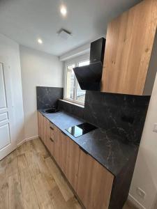 uma cozinha com um balcão preto e uma janela em Appartement tout confort em Harfleur