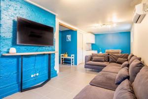 salon z kanapą i telewizorem na niebieskiej ścianie w obiekcie Chalet La Cordée, 160m2, 4 chambres, sauna w mieście Saint-Gervais-les-Bains