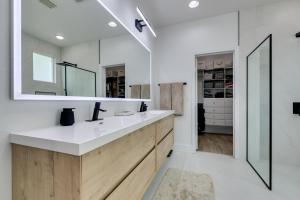 ein Bad mit einem Waschbecken und einem Spiegel in der Unterkunft Timeless 3 Bed 2 Bath Sanctuary in Las Vegas