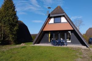 ein Gebäude mit Tischen und Stühlen davor in der Unterkunft Holiday home Amalie, Burhave in Burhave