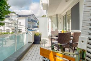 a balcony with chairs and tables on a building at ZingstUrlauber in Zingst