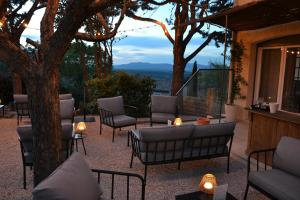 a patio with chairs and a table and a tree at Hôtel La Garrigue & Bar Le Perchoir in Venasque +118 photos