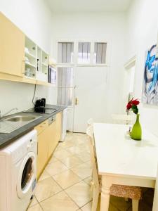 eine Küche mit einer Waschmaschine und einem Tisch in der Unterkunft Cozy Studio LG in Wien