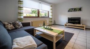 sala de estar con sofá y mesa en Moseltraum, en Bruttig-Fankel