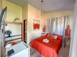 a bedroom with a red bed with two rings on it at Villa Madeira in Alto Paraíso de Goiás