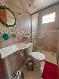 y baño con aseo, lavabo y espejo. en Villa Madeira, en Alto Paraíso de Goiás