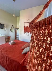 a bedroom with a red bed with a red blanket at Villa Madeira in Alto Paraíso de Goiás