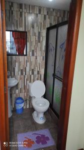 y baño con aseo y lavamanos. en Gran Hostal Casa Luz, en Quito