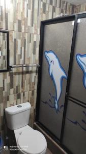 a bathroom with a toilet and a dolphin shower stall at Gran Hostal Casa Luz in Quito