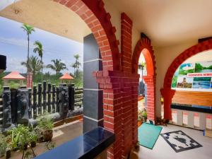 Habitación con paredes de ladrillo y arcos. en OYO Flagship Aiswarya Residency, en Wayanad
