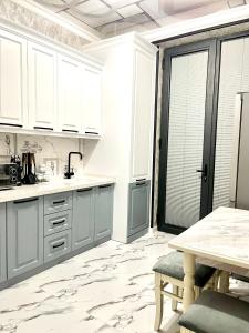 a kitchen with white cabinets and a marble floor at Residential Complex «Yunusabad - Khon Saroy» in Tashkent