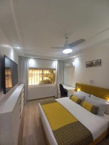 a bedroom with a large bed with a yellow blanket at Piscine privative et prestations haut de gamme in Dakar