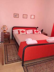 een slaapkamer met een bed met rode en witte kussens bij Hausen Margaret's in Kuçovë