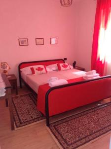 een rode slaapkamer met een bed met rode kussens bij Hausen Margaret's in Kuçovë