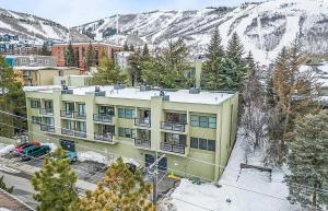 an apartment building in front of a snow covered mountain at Edelweiss Haus by All Seasons Resort Lodging in Park City
