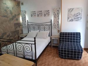 a bedroom with a black bed and a chair at Apartamento Pepa Bajondillo in Torremolinos
