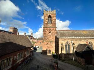 uma velha igreja de tijolos com uma torre com um relógio em FARRIERS ARMS em Worcester