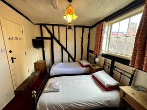 two twin beds in a room with a window at FARRIERS ARMS in Worcester