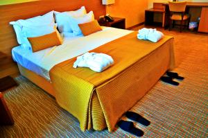 um quarto de hotel com uma cama grande com toalhas em Hotel Lusitania Congress & Spa na Guarda mais 30 fotografias