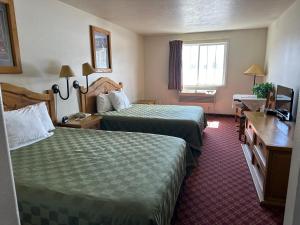 a hotel room with two beds and a desk at Columbine Inn and Suites in Leadville