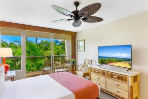 ein Schlafzimmer mit einem Bett und einem großen Fenster in der Unterkunft Maui Banyan Vacation Club in Wailea