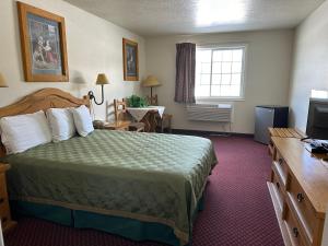 Habitación de hotel con cama y TV en Columbine Inn and Suites, en Leadville