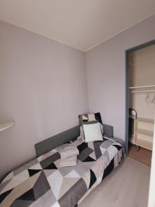 a bedroom with a black and white bed in a room at Studio Moderne - Plage du Grazel in Gruissan