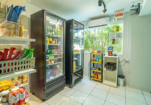 a store with an open refrigerator in a room at SPT - Studios Convenientes em Blumenau/SC in Blumenau