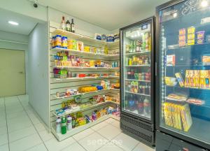 a refrigerator filled with lots of food in a store at SPT - Studios Convenientes em Blumenau/SC in Blumenau