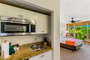 a kitchen with a sink and a bed in a room at Maui Banyan Vacation Club in Wailea