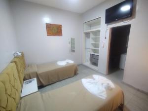 een woonkamer met 2 bedden en een bank bij Hotel Los Olivos Termal Spa in Termas de Río Hondo