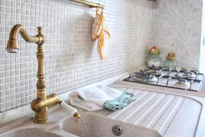a kitchen sink with a faucet and a stove at CASA CHITI TAORMINA in Taormina +6 photos
