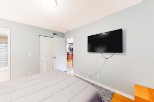 a bedroom with a bed and a flat screen tv on the wall at The Adventure Pad, Unit 1 in Branson