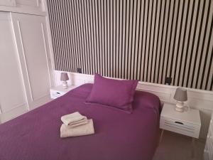 プラヤ・デ・ラス・アメリカスにあるVila Lavandaのベッドルーム1室(紫色のベッド1台、タオル付)