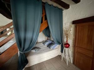 um quarto com uma cama com uma cortina azul em Gîte La Carillonnerie em Bossay-sur-Claise