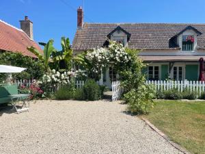 uma casa com uma cerca branca e um jardim em Gîte La Carillonnerie em Bossay-sur-Claise