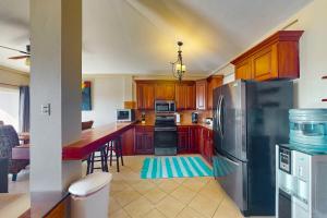 uma cozinha com armários de madeira e um frigorífico de aço inoxidável em Suite B301 at Mara Laguna em San Pedro