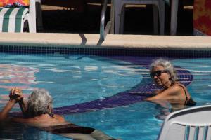 Dos mujeres están en una piscina en Bungalows Las Tortugas en Lo de Marcos