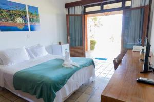 a bedroom with a bed and a desk and a television at Hotel Praia dos Carneiros in Tamandaré +77 photos