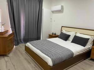 Un dormitorio con una cama y una cómoda y una ventana. en PoliaNapa Nest, en Ayia Napa