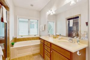 a bathroom with a tub and a sink and a tub and a bath tub at The Owl's Nest at the Reserve in Sugar Mountain +15 photos