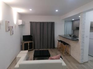 Una sala de estar con un sofá blanco y una cocina. en PoliaNapa Nest, en Ayia Napa 9 fotos más