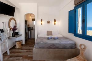 a bedroom with a bed with blue pillows on it at San Constantino Boutique Villa in Fira