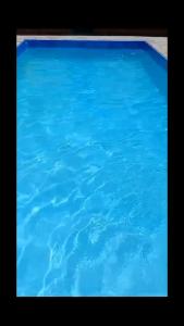 une grande piscine d'eau bleue dans l'établissement Chácara Elshaday Shalom Arujá, à Arujá