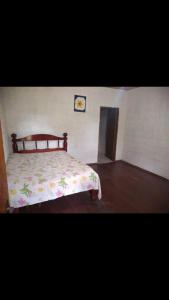 - une chambre dotée d'un lit avec un couvre-lit floral dans l'établissement Chácara Elshaday Shalom Arujá, à Arujá