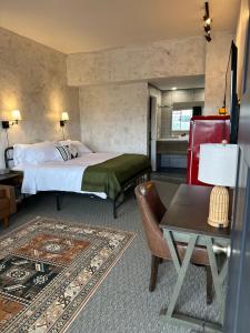 a hotel room with a bed and a table at Neon Cowboy Roadhouse at Hunters Hot Springs in Lakeview +12 photos