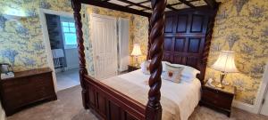 a bedroom with a canopy bed and two lamps at Camelot Castle Hotel in Tintagel