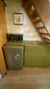 a microwave sitting on top of a refrigerator under a staircase at Casa Edka in Ensenada